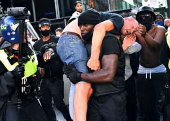 Λονδίνο : Viral η φωτογραφία με μαύρο άνδρα που κουβαλά ακροδεξιό στους ώμους του, σώζοντας τον απο βέβαιο θανατο.